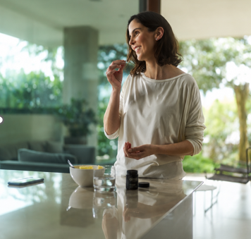Woman taking her almä capsules as part of her morning routine